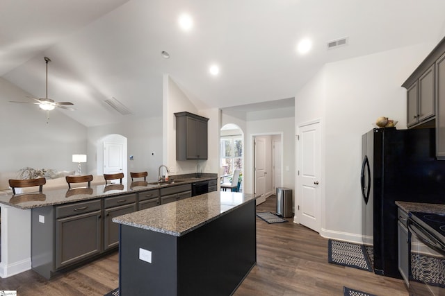 kitchen featuring visible vents, arched walkways, a sink, and gray cabinetry