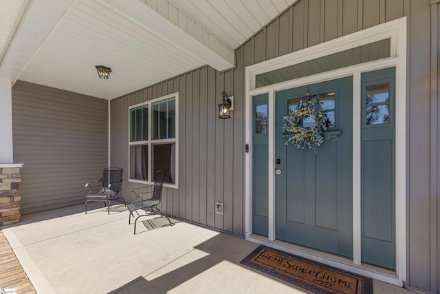 doorway to property with board and batten siding and covered porch