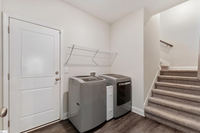 laundry room featuring laundry area, dark wood-type flooring, washing machine and clothes dryer, and baseboards