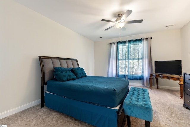 bedroom featuring light colored carpet, ceiling fan, and baseboards