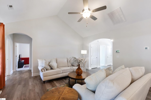 living area with arched walkways, wood finished floors, and visible vents