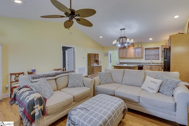 living area featuring recessed lighting, ceiling fan with notable chandelier, visible vents, vaulted ceiling, and light wood finished floors