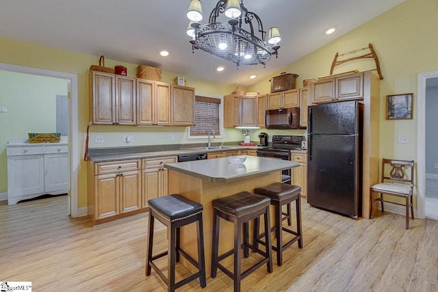 kitchen featuring lofted ceiling, black appliances, light wood-type flooring, and a sink