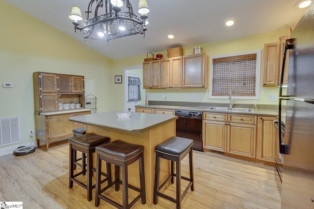 kitchen with a kitchen island, a sink, visible vents, light wood-type flooring, and black appliances