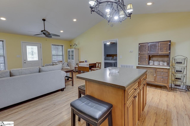 kitchen with light wood-type flooring, open floor plan, visible vents, and a kitchen island