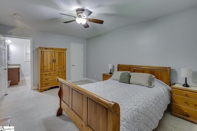 bedroom with light carpet, ceiling fan, baseboards, and ensuite bathroom