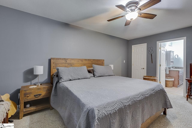 bedroom featuring connected bathroom, a sink, and ceiling fan