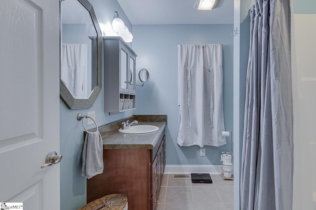 bathroom with visible vents, vanity, baseboards, and tile patterned floors