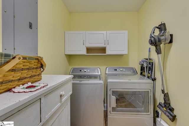 clothes washing area featuring independent washer and dryer and cabinet space