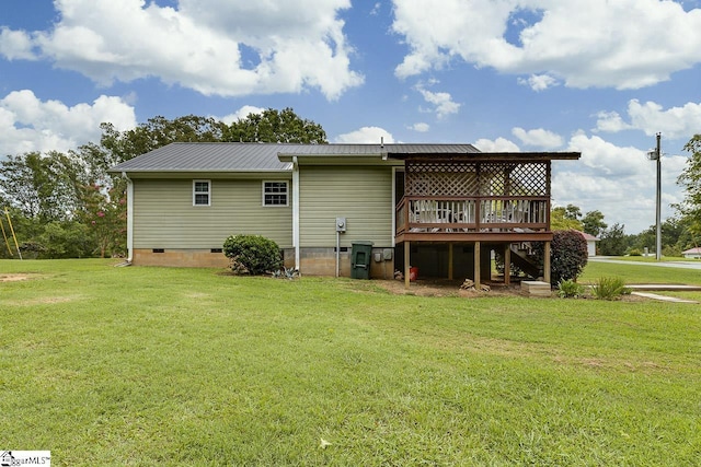 back of house featuring a deck, metal roof, stairway, crawl space, and a lawn