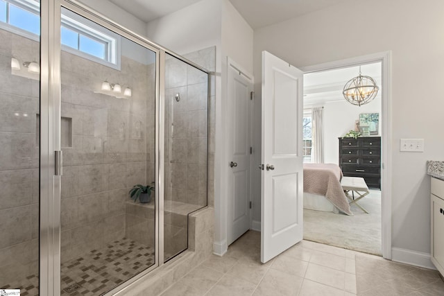 full bathroom with ensuite bathroom, a stall shower, vanity, tile patterned flooring, and baseboards