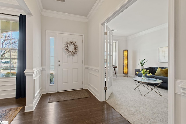 entryway with ornamental molding, plenty of natural light, and wood finished floors