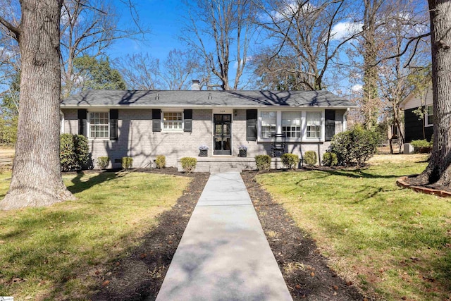 view of front of house with a front yard and brick siding