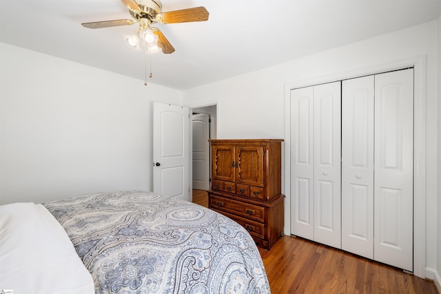 bedroom with a ceiling fan, a closet, and wood finished floors