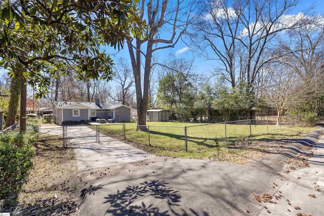 exterior space with driveway, a front lawn, a fenced front yard, and a gate