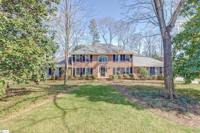 colonial house with brick siding and a front lawn