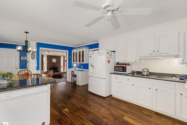 kitchen with white appliances, dark countertops, white cabinetry, and under cabinet range hood