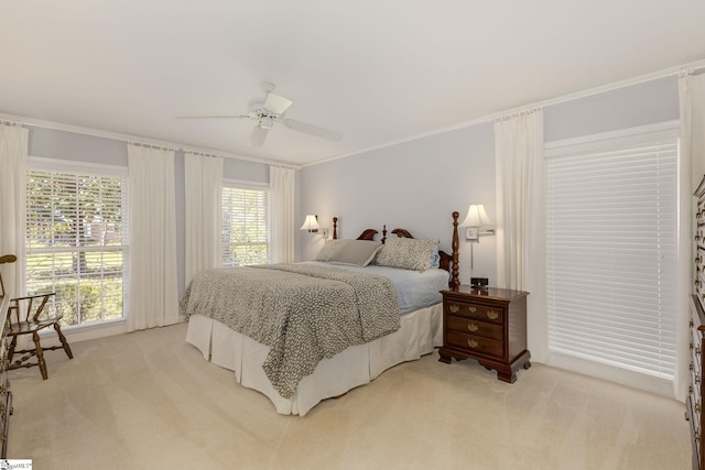 bedroom with crown molding, a ceiling fan, and light colored carpet