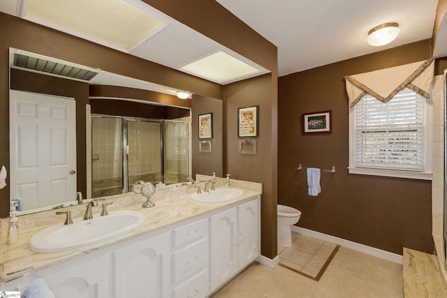 full bath with double vanity, a stall shower, a sink, and baseboards