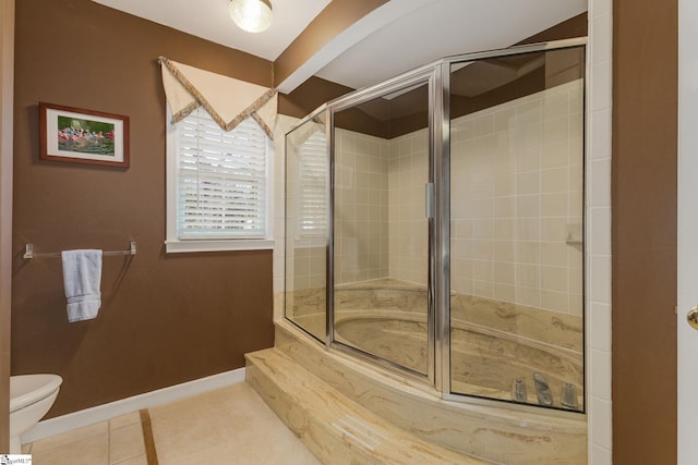 bathroom with toilet, baseboards, tiled shower, and tile patterned floors