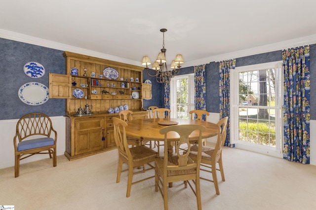 dining area with ornamental molding, light carpet, a notable chandelier, and wallpapered walls