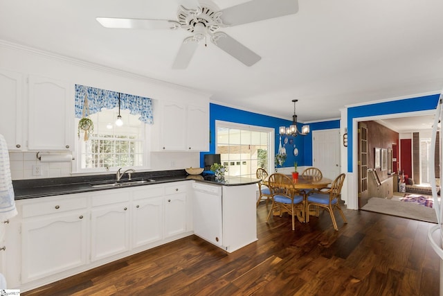 kitchen with dark countertops, dishwasher, white cabinetry, and a sink