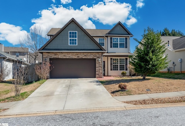 craftsman-style home with a garage, driveway, stone siding, and fence