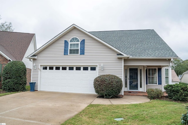 traditional-style home featuring a garage, a front yard, concrete driveway, and a shingled roof