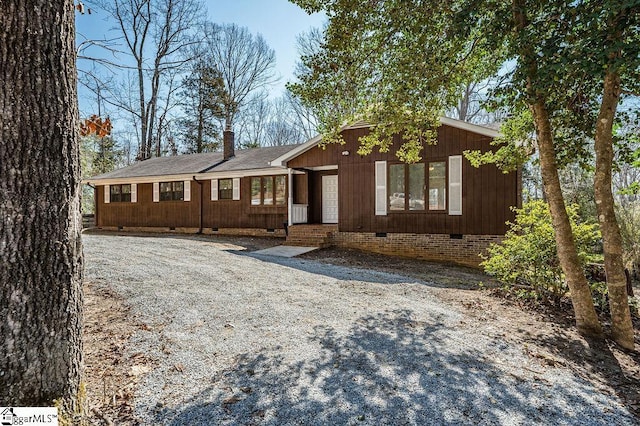 view of front of home featuring crawl space, roof with shingles, and a chimney