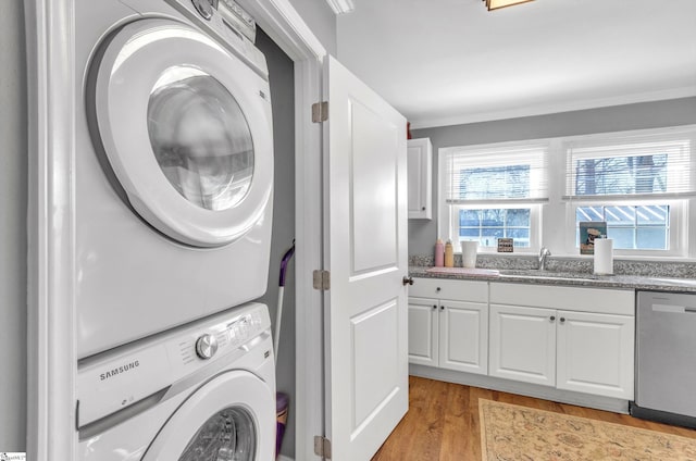 washroom with light wood-style flooring, laundry area, stacked washer / dryer, a sink, and crown molding