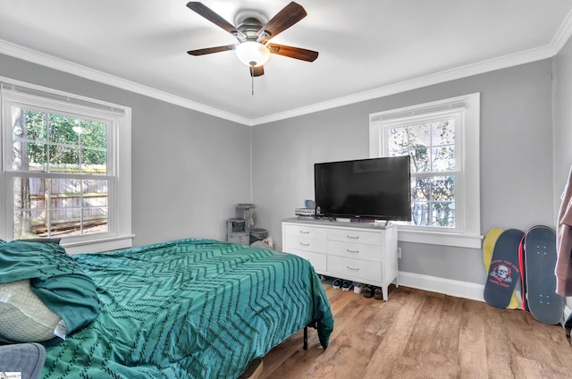 bedroom featuring a ceiling fan, light wood-style flooring, baseboards, and crown molding