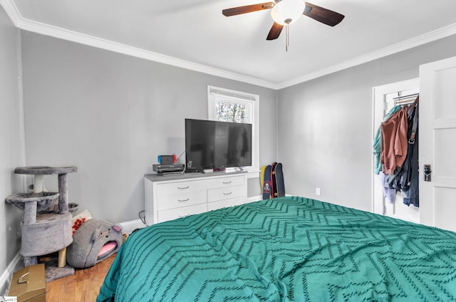 bedroom with crown molding, baseboards, and wood finished floors