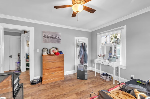 interior space with light wood-style floors, crown molding, baseboards, and a ceiling fan