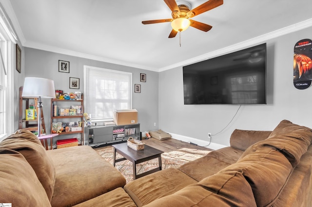 living room featuring a ceiling fan, baseboards, crown molding, and wood finished floors