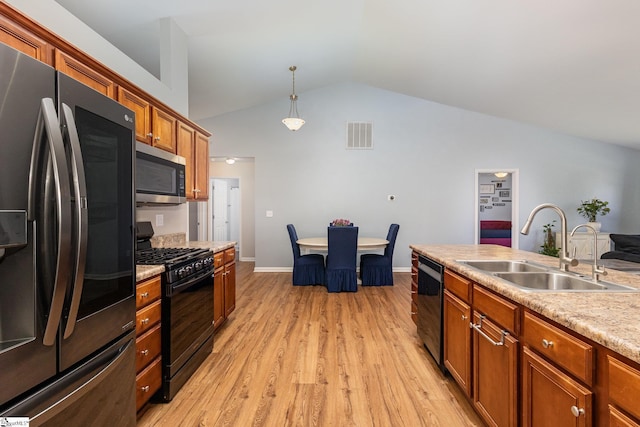 kitchen featuring visible vents, brown cabinetry, a sink, light wood-type flooring, and black appliances