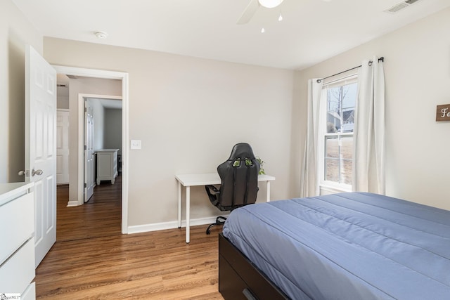 bedroom with light wood finished floors, visible vents, baseboards, and ceiling fan