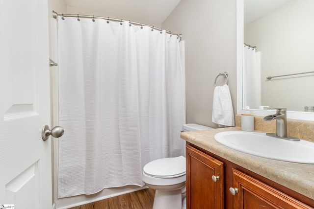 full bathroom featuring toilet, wood finished floors, and vanity