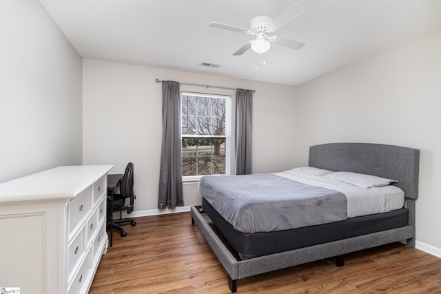 bedroom with ceiling fan, light wood-style flooring, visible vents, and baseboards