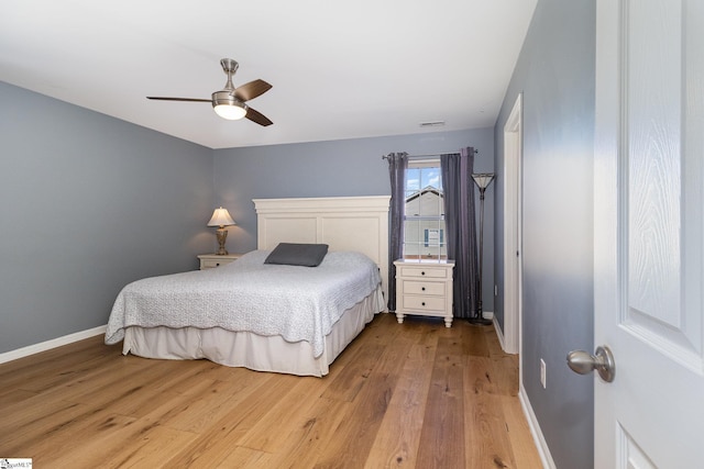 bedroom with a ceiling fan, light wood-style flooring, and baseboards