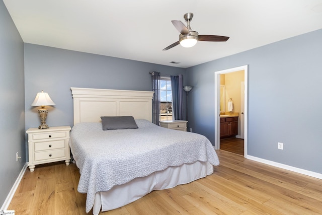 bedroom featuring visible vents, light wood-style floors, a ceiling fan, ensuite bath, and baseboards