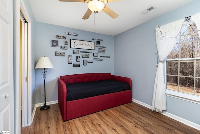 sitting room featuring visible vents, ceiling fan, baseboards, and wood finished floors