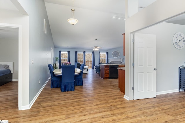 dining space with baseboards, high vaulted ceiling, light wood-style floors, and a healthy amount of sunlight