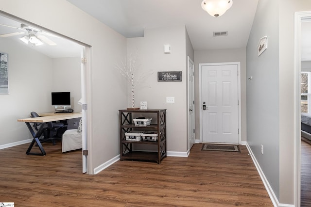 interior space with baseboards, visible vents, and wood finished floors