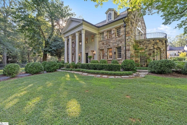 view of front of home featuring stone siding and a front yard