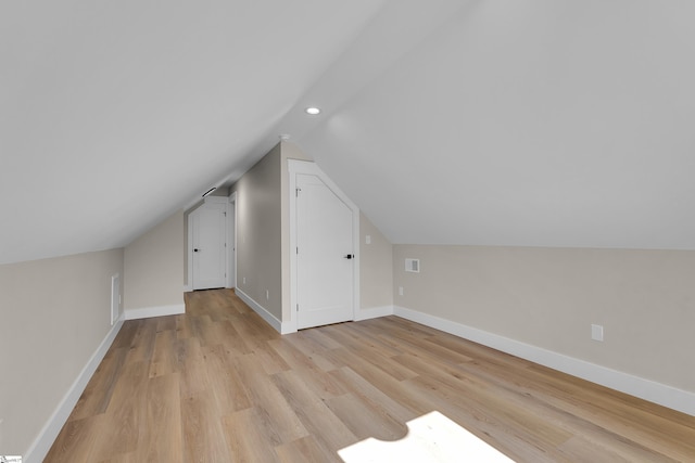 additional living space featuring lofted ceiling, recessed lighting, visible vents, light wood-style floors, and baseboards