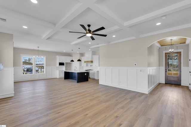 unfurnished living room with beamed ceiling, coffered ceiling, and a wealth of natural light