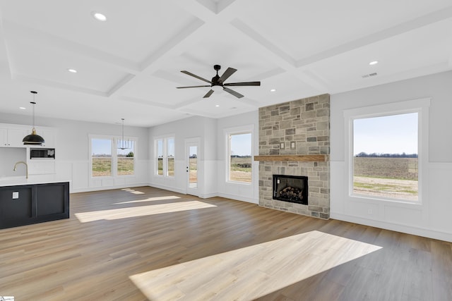 794 Hebron Church Rd, Iva, SC 29655 - unfurnished living room featuring a healthy amount of sunlight, coffered ceiling, a sink, and a stone fireplace