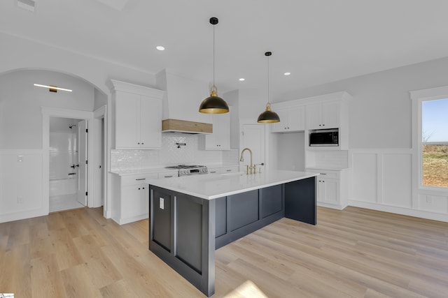 794 Hebron Church Rd, Iva, SC 29655 - kitchen with arched walkways, white cabinets, light countertops, backsplash, and built in microwave