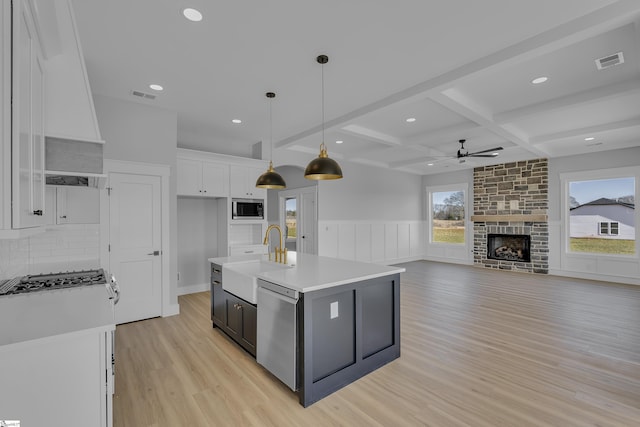 kitchen with white cabinetry, visible vents, stainless steel appliances, and a sink