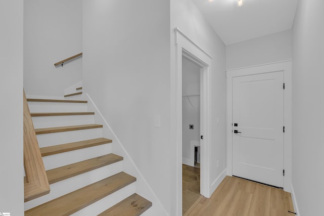 foyer with stairway, light wood-style flooring, and baseboards